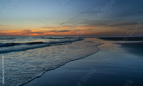 Zachód słońca na plaży w Egmond aan Zee, Holandia Północna.