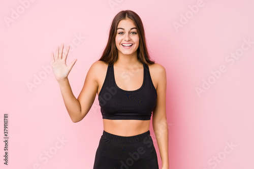 Young caucasian fitness woman doing sport isolated smiling cheerful showing number five with fingers.