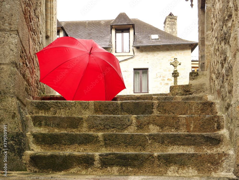 Photo of a red umbrella fallen down the stone stairs