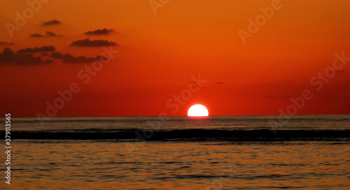 Red sunset on the sea. Dramatic sunset sky. Sun setting. Sundown. Indian ocean. Romantic twilight.  Dark waves. Mauritius island.