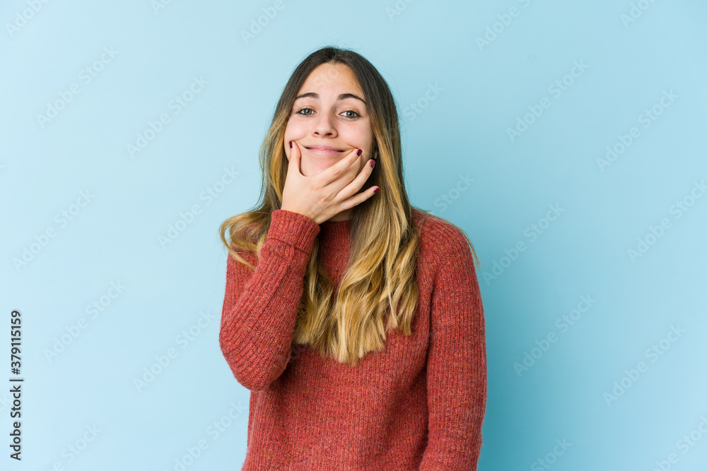Young caucasian woman isolated on blue background doubting between two options. Young caucasian woman isolated on blue background doubting between two options.