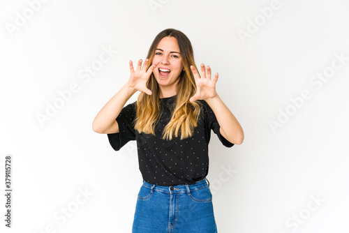 Young caucasian woman isolated on white background showing claws imitating a cat, aggressive gesture.