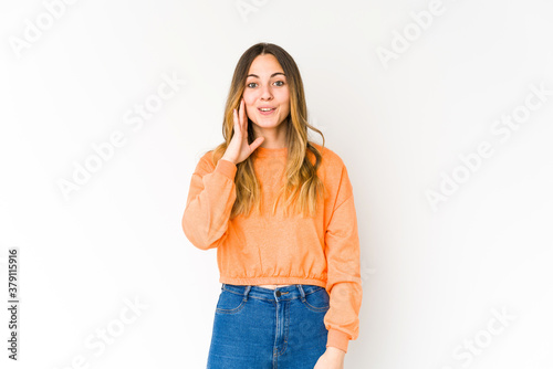 Young caucasian woman isolated on white background shouts loud, keeps eyes opened and hands tense. © Asier
