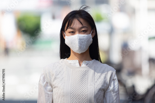マスク姿の若い女性。 COVID-19 パンデミックコロナウイルス。病気の拡大を防ぐマスクを着けている若い女性のポートレイト。