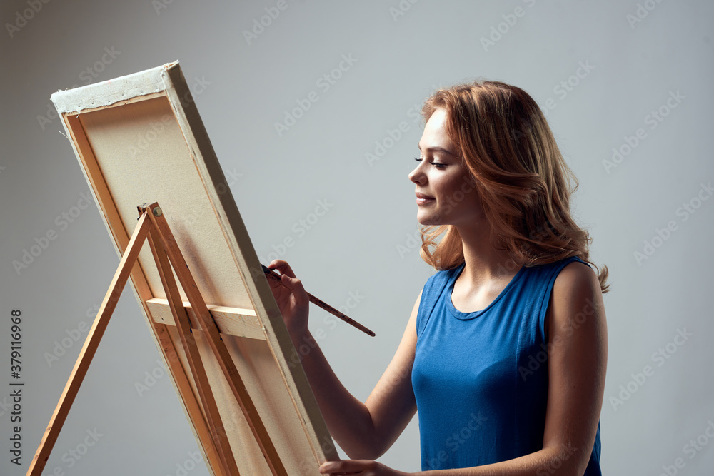 Woman artist with brush paint on easel art hobby light background
