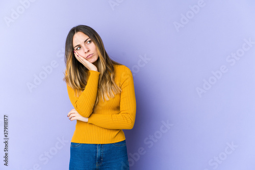 Young caucasian woman isolated on purple background who is bored, fatigued and need a relax day.