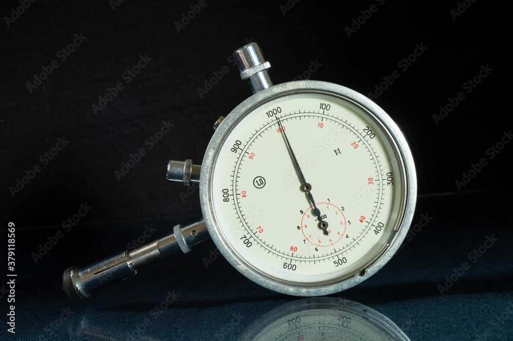 Mechanical tachometer with arrow on black background