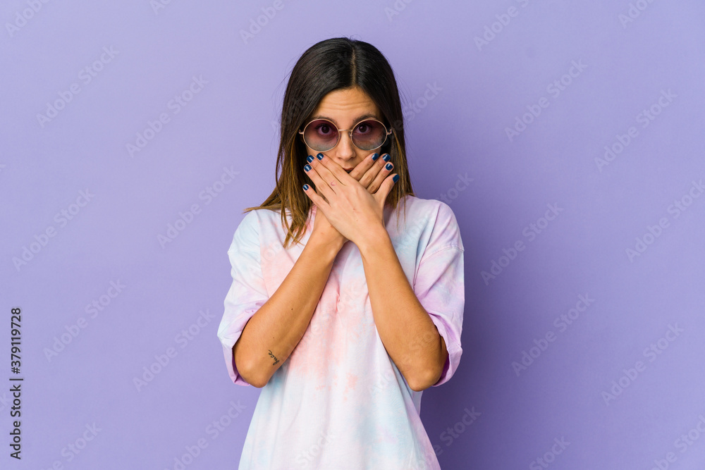Young hippie woman isolated on purple background covering mouth with hands looking worried. Young hippie woman isolated on purple background covering mouth with hands looking worried.