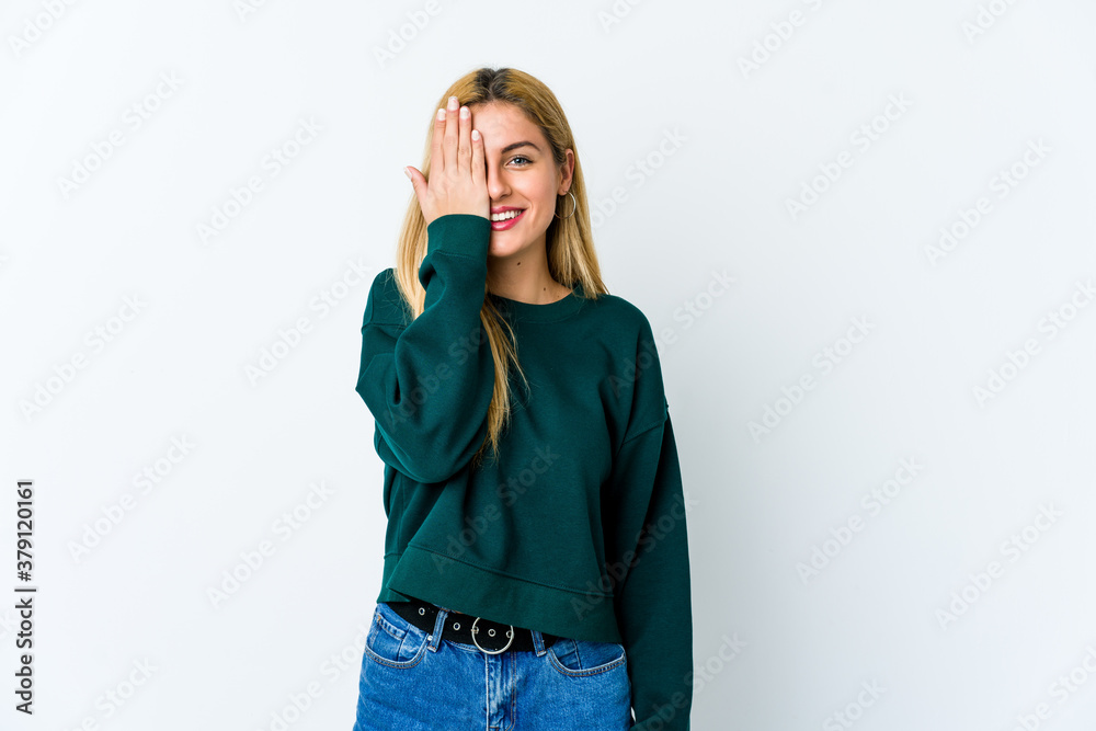 Young blonde woman isolated on white background having fun covering half of face with palm. Young blonde woman isolated on white background having fun covering half of face with palm.