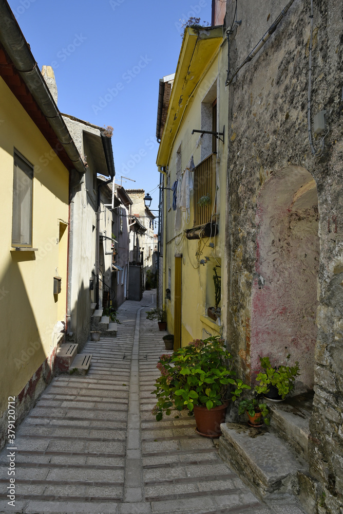 Fototapeta premium A narrow street among the old houses of Baselice, a small town in the province of Benevento, Italy.