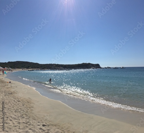 Fototapeta Naklejka Na Ścianę i Meble -  Sunny beach in Greece on sunny day with mountain on background clear blue sky