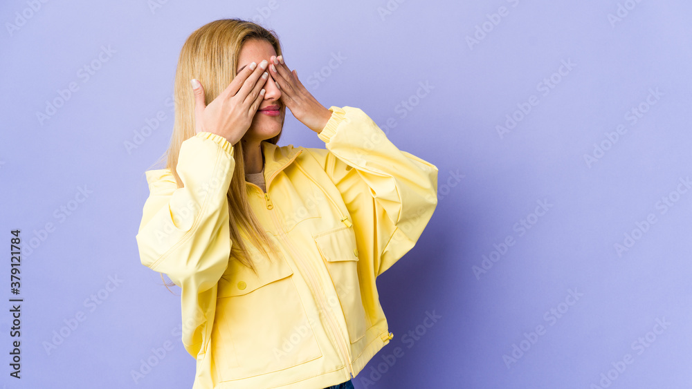 Young blonde woman isolated on purple background afraid covering eyes with hands. Young blonde woman isolated on purple background afraid covering eyes with hands.