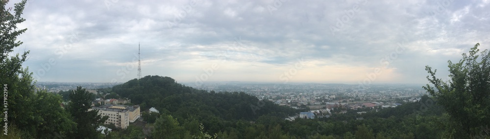 City panorama of Lviv in Ukraine on cloudy summer morning with tower on mountain