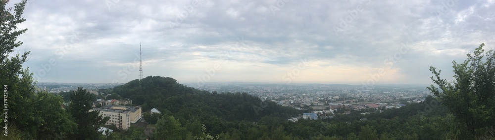 Obraz premium City panorama of Lviv in Ukraine on cloudy summer morning with tower on mountain