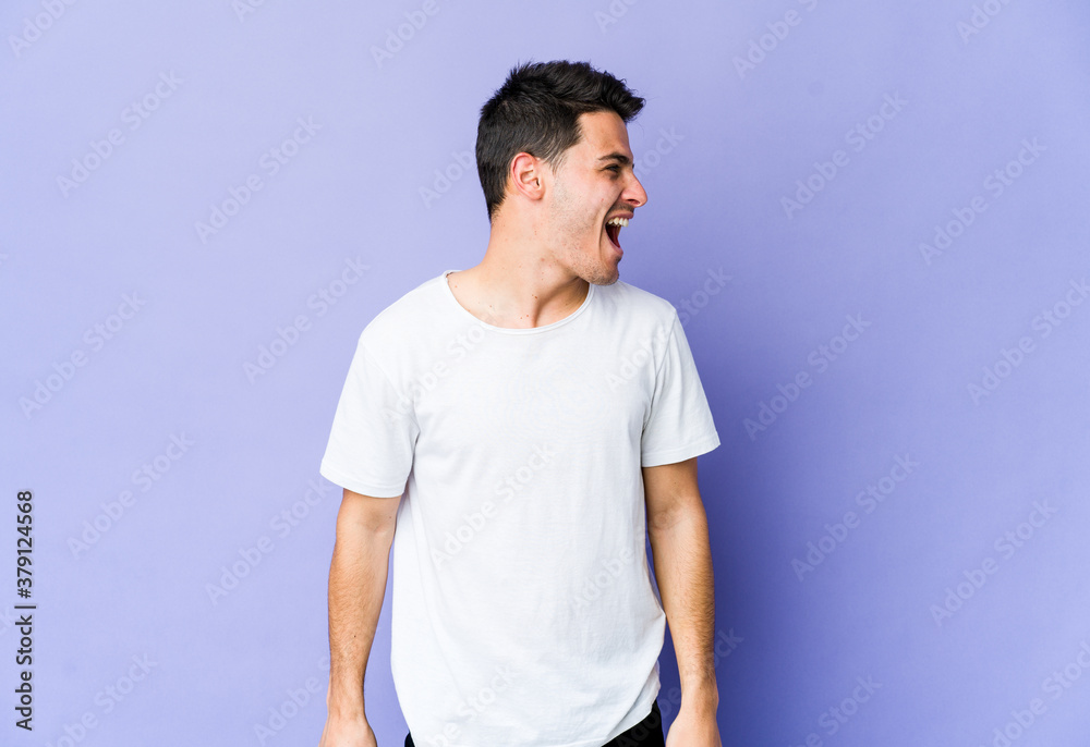 Young caucasian man isolated on purple background shouting very angry, rage concept, frustrated. Young caucasian man isolated on purple background shouting very angry, rage concept, frustrated.