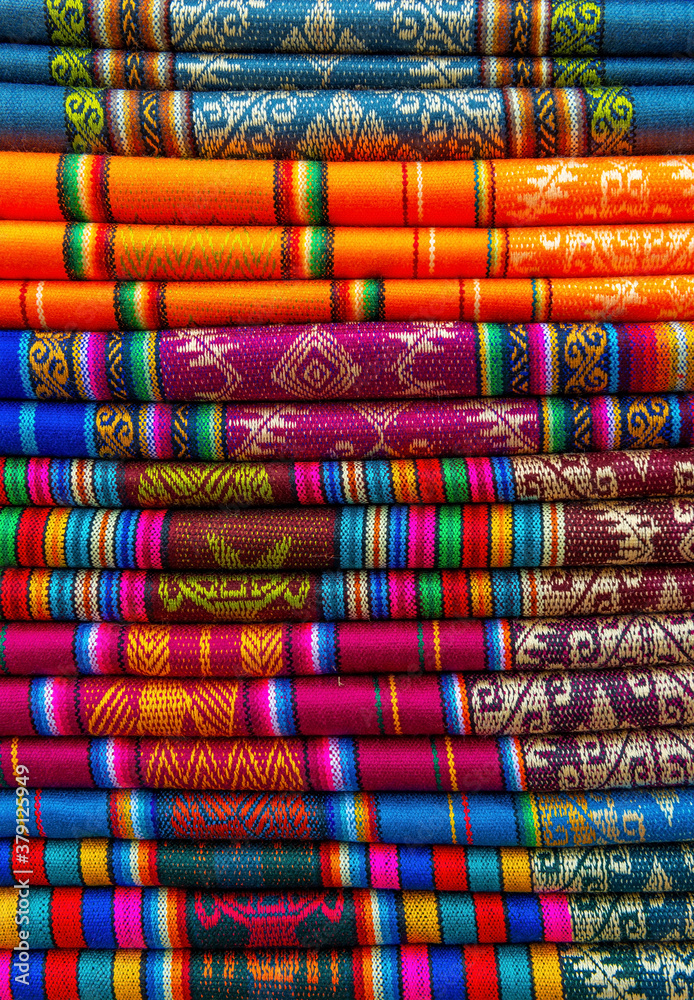 A pile of colorful traditional textiles in the Andes mountains sunday market of Otavalo, north of Quito, Ecuador. A pile of colorful traditional textiles in the Andes mountains sunday market of Otavalo, north of Quito, Ecuador.