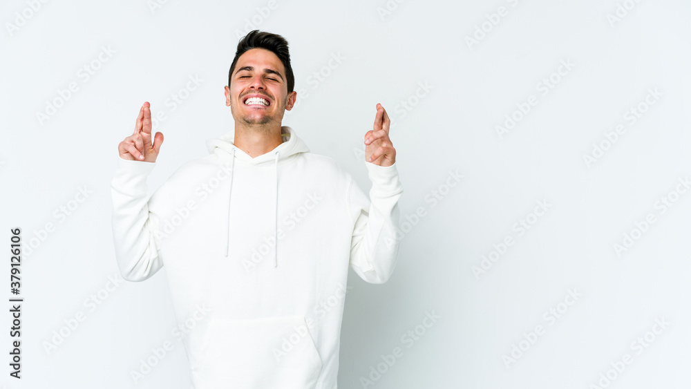 Young caucasian man isolated on white background crossing fingers for having luck Young caucasian man isolated on white background crossing fingers for having luck