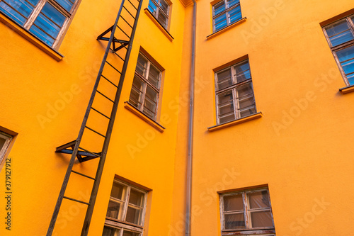 Old orange industrial building with fire escape leading