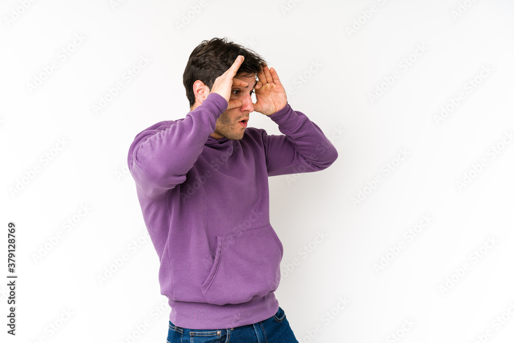 Young man isolated on white background keeping eyes opened to find a success opportunity. Young man isolated on white background keeping eyes opened to find a success opportunity.