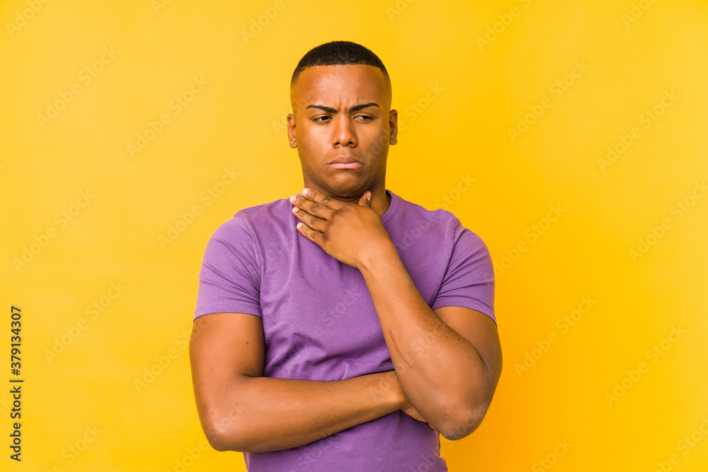 Young latin man isolated on yellow background suffers pain in throat due a virus or infection. Young latin man isolated on yellow background suffers pain in throat due a virus or infection.