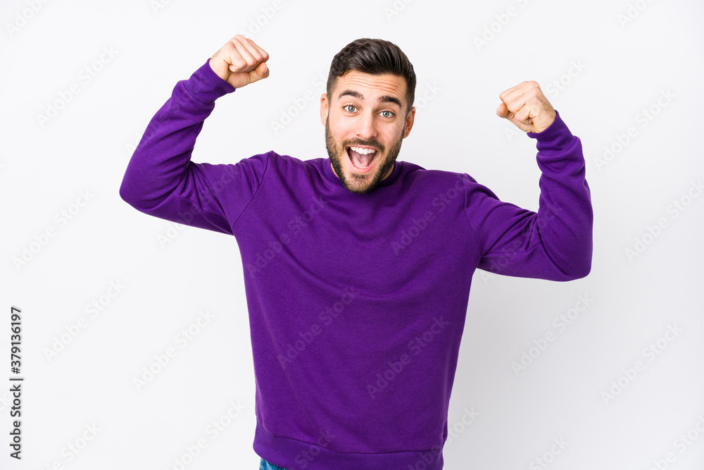 Fototapeta premium Young caucasian man against a white background isolated showing strength gesture with arms, symbol of feminine power