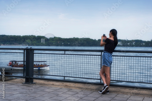 Fototapeta Naklejka Na Ścianę i Meble -  A chinese woman taking pictures in old port montreal