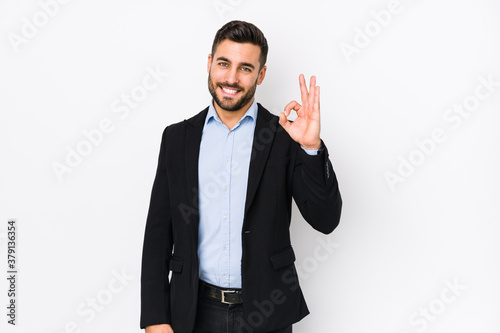 Young caucasian business man against a white background isolated cheerful and confident showing ok gesture.