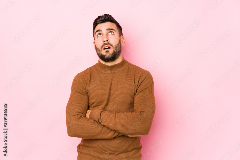 Young caucasian man against a pink background isolated tired of a repetitive task.