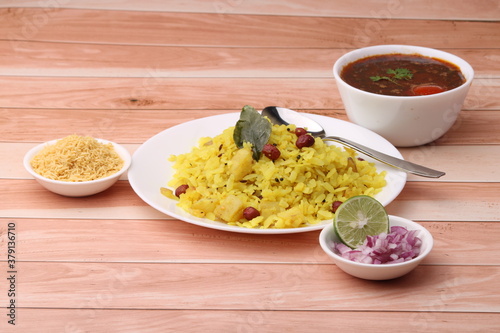 Aloo/Kanda Poha or Tarri Pohe with spicy chana masala/curry. Served in ceramic plate. photo