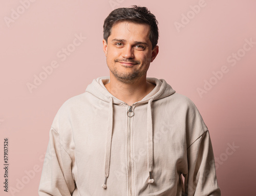 White guy in hoodie on pink background © Masson