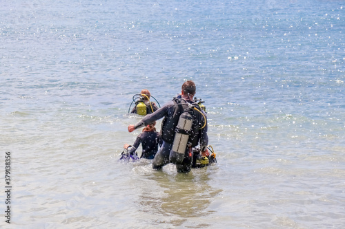 divers enter the water on the beach