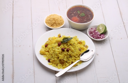 Aloo/Kanda Poha or Tarri Pohe with spicy chana masala/curry. Served in ceramic plate. photo