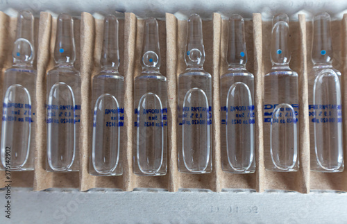 Transparent glass medical ampoules in cardboard packaging. Ampoules with medicine for injection.