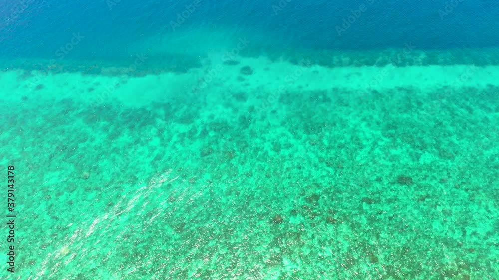 Turquoise lagoon surface on atoll and coral reef, copy space for text. Top view transparent turquoise ocean water surface. Turquoise lagoon surface on atoll and coral reef, copy space for text. Top view transparent turquoise ocean water surface.