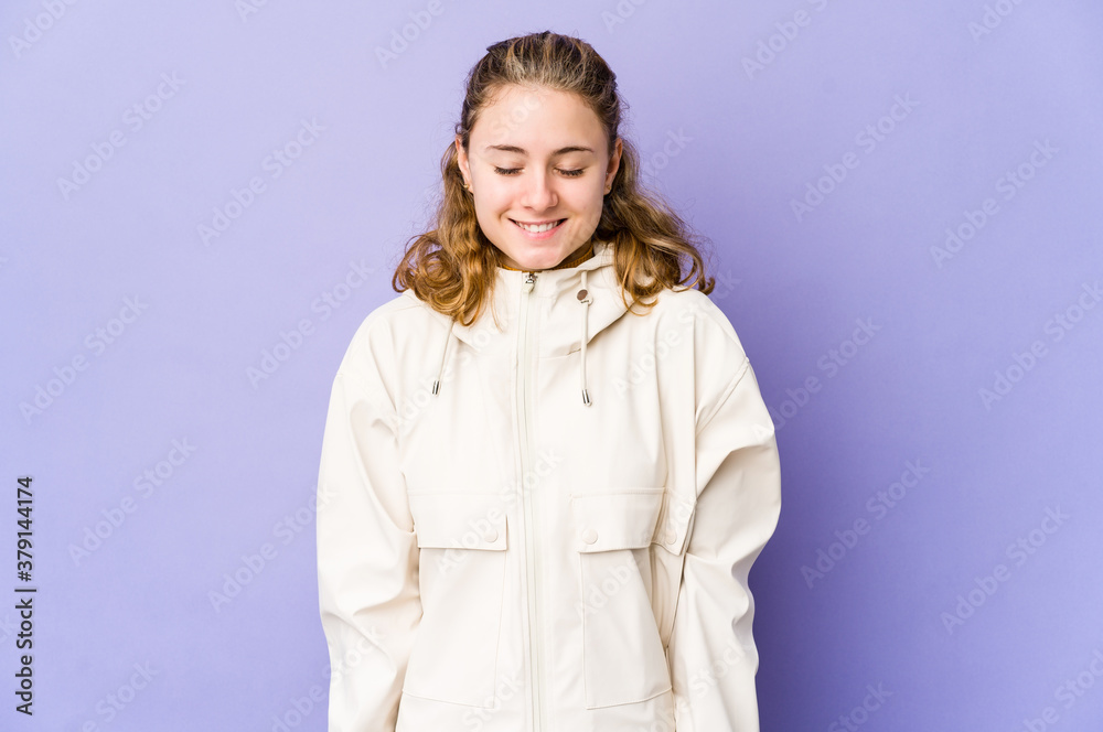 Young caucasian woman on purple background laughs and closes eyes, feels relaxed and happy. Young caucasian woman on purple background laughs and closes eyes, feels relaxed and happy.