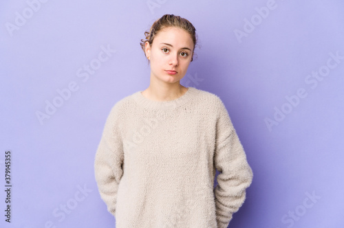 Young caucasian woman on purple background sad, serious face, feeling miserable and displeased.