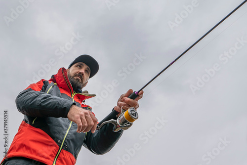 Fishing. Fisherman in action, man catch fish by spinning rod. Bottom view © FedBul