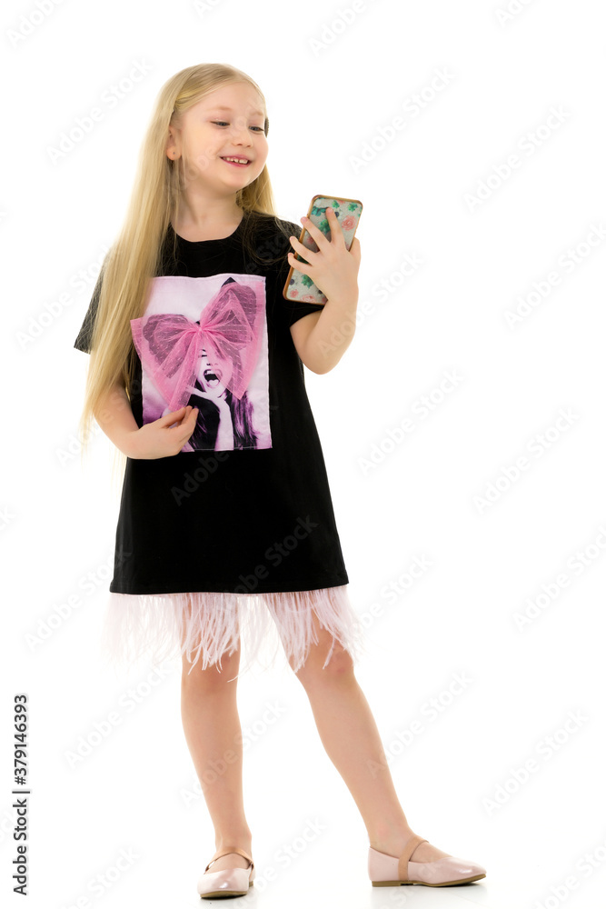 The girl is using a cell phone.The concept of people and technology. The girl is using a cell phone.The concept of people and technology.