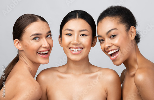 Three Joyful Female Models Posing Smiling To Camera, Studio Shot