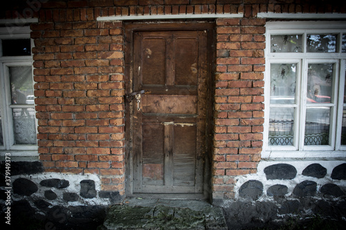 old door of brick building close up. The red brick wall and wooden door shot © zef art