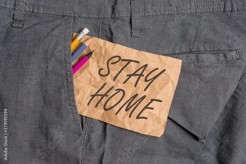 Word writing text Stay Home. Business photo showcasing not go out for an activity and stay inside the house or home Writing equipment and brown note paper inside pocket of man work trousers photo