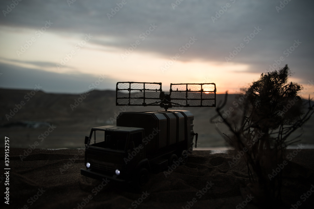 Silhouette of mobile air defence truck with radar antenna during sunset. Satellite dishes or radio antennas against evening sky. Silhouette of mobile air defence truck with radar antenna during sunset. Satellite dishes or radio antennas against evening sky.
