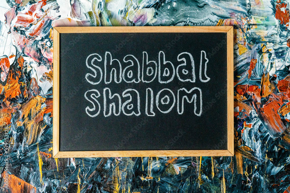 Jewish greetings Shabbat Shalom painted on a chalk board.