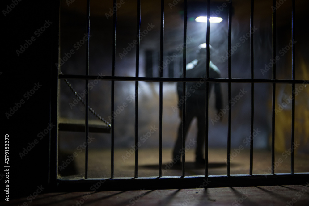Jail or prison cell. Man in prison man behind bars concept. Old dirty grunge prison miniature. Dark prison interior creative decoration. Selective focus Jail or prison cell. Man in prison man behind bars concept. Old dirty grunge prison miniature. Dark prison interior creative decoration. Selective focus