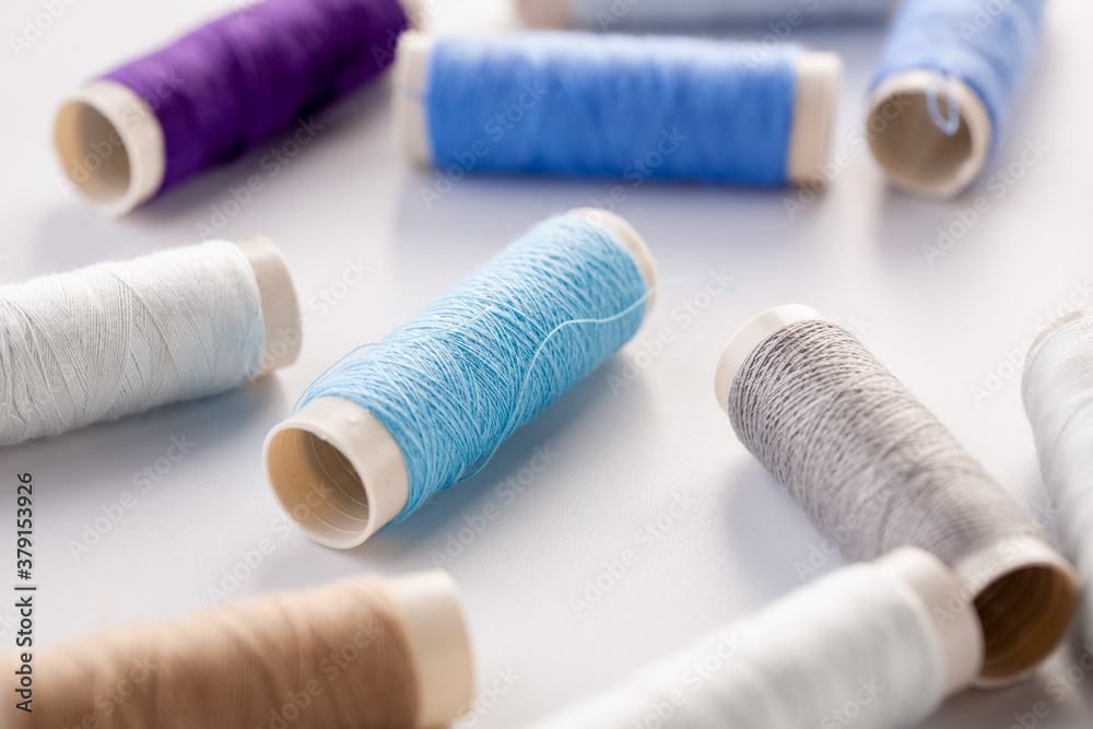 Skeins of blue thread are scattered on a gray background. Sewing machine threads. Materials for sewing. Skeins of blue thread are scattered on a gray background. Sewing machine threads. Materials for sewing.