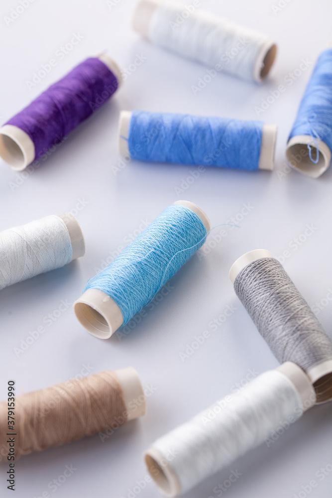 Skeins of blue thread are scattered on a gray background. Sewing machine threads. Materials for sewing. Skeins of blue thread are scattered on a gray background. Sewing machine threads. Materials for sewing.