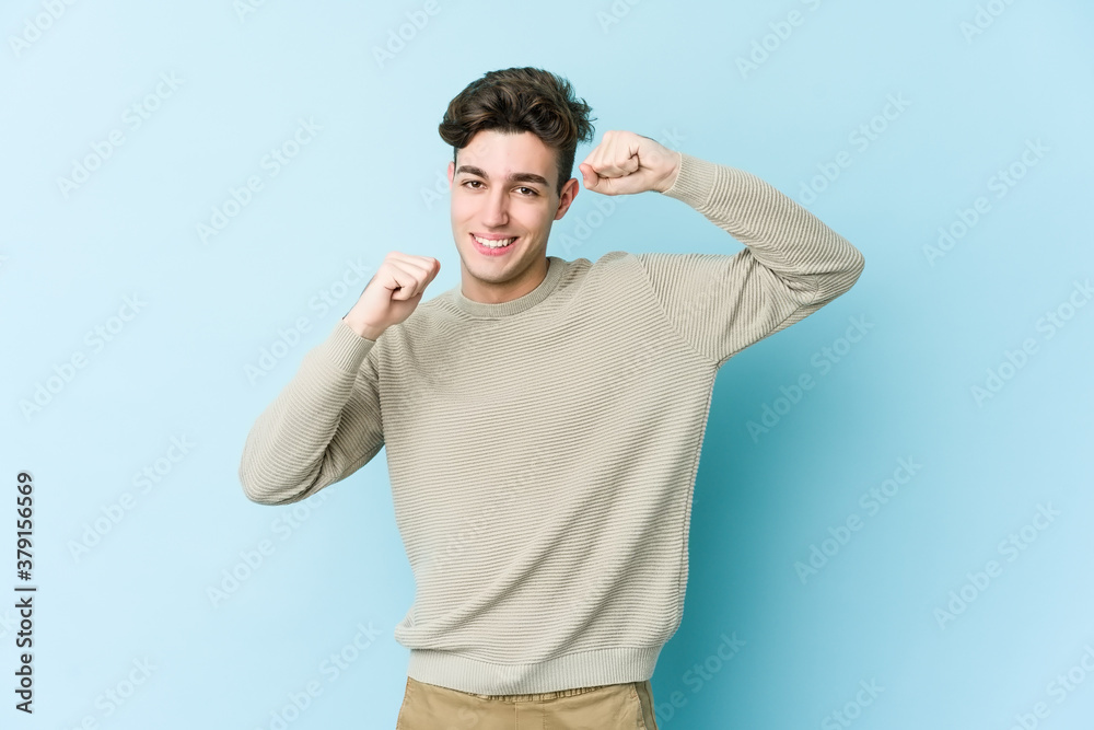Young caucasian man isolated on blue background celebrating a special day, jumps and raise arms with energy. Young caucasian man isolated on blue background celebrating a special day, jumps and raise arms with energy.