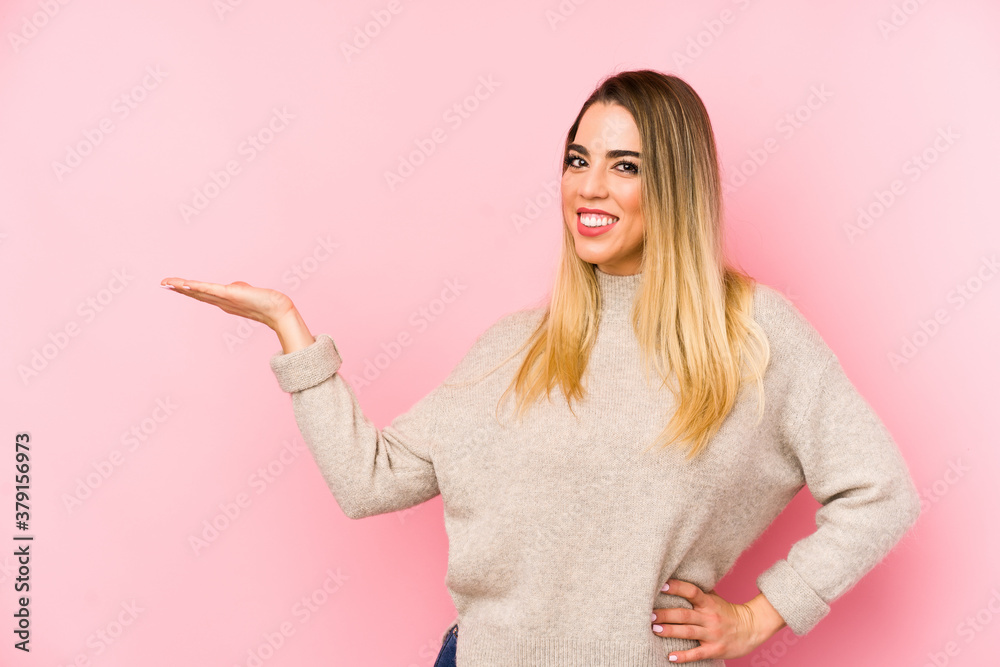 Middle age woman over isolated background showing a copy space on a palm and holding another hand on waist. Middle age woman over isolated background showing a copy space on a palm and holding another hand on waist.