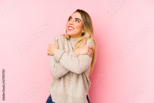 Middle age woman over isolated background hugs, smiling carefree and happy.