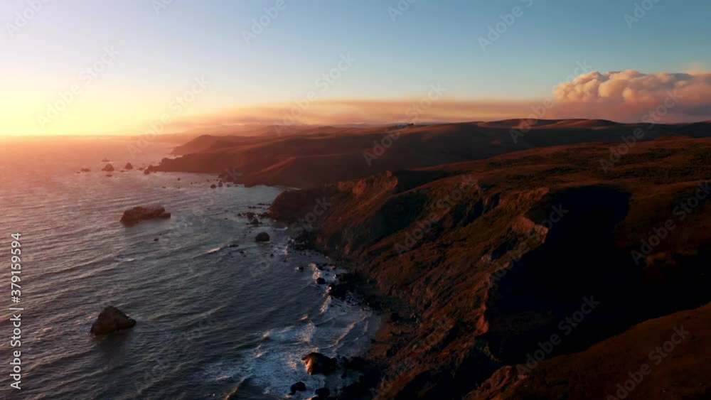 California PCH Sunset cliff golden hour sunshine with wildfire smoke on horizon west coast.